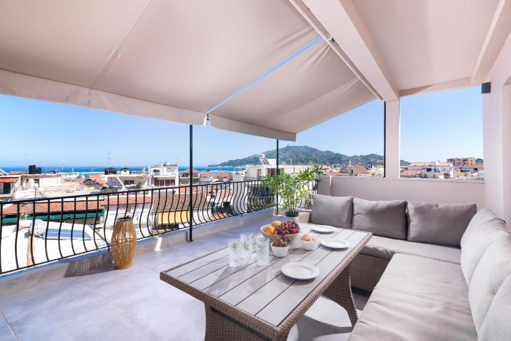 a living room with a couch and a table on a balcony at Lithies Zante Living in Zakynthos Town