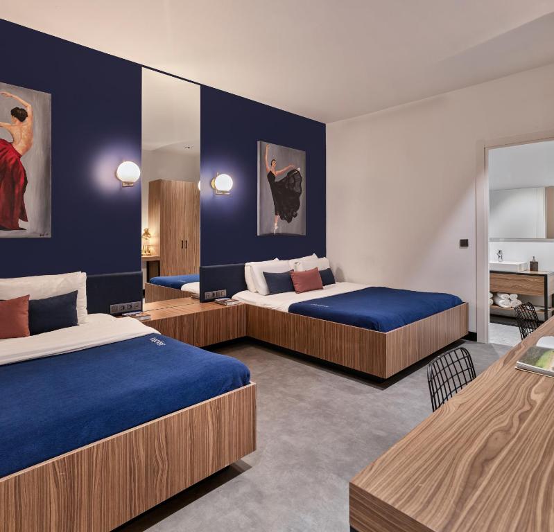 two beds in a room with blue walls at Kepler Club Sabiha Gökçen Airport - International Transit Area in Istanbul