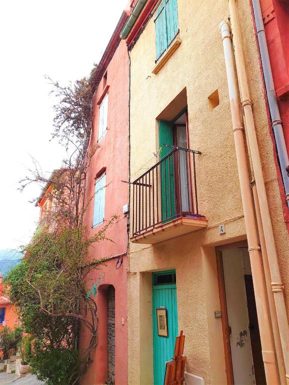 - un bâtiment avec une porte verte et un balcon dans l'établissement 2FAN4 Studio Intra-murros proche plage, à Collioure