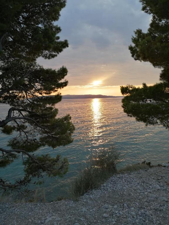 a sunset over a body of water with trees at Apartment Rita in Makarska
