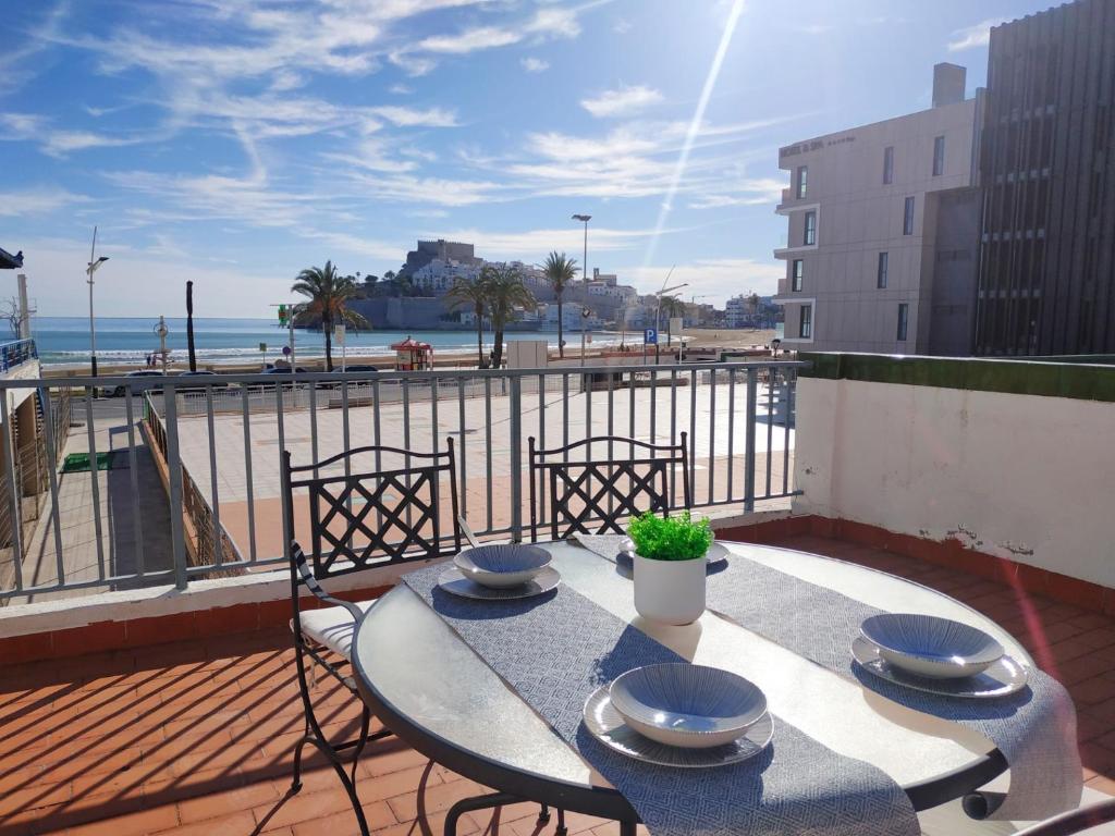 a table on a balcony with a view of the beach at Duplex vista mar Peñiscola Playa Orangecosta in Peniscola
