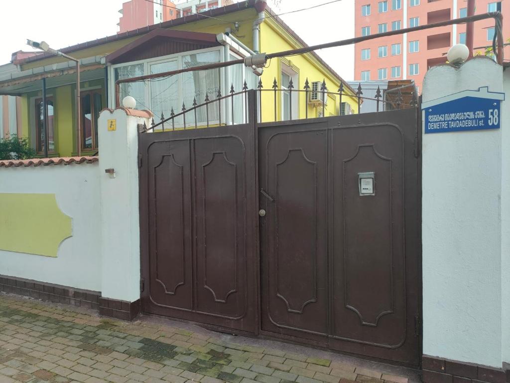 um par de portas castanhas em frente a um edifício em Guest House Nadejda em Batumi