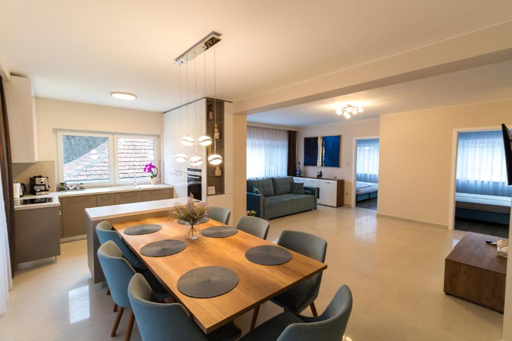 comedor y sala de estar con mesa y sillas en Thermal Lux Weninger Apartman en Kiskunhalas