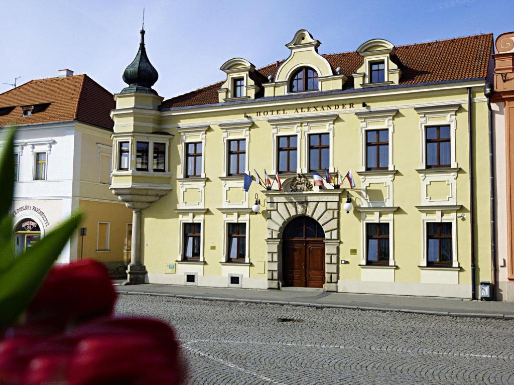 ein großes gelbes Gebäude mit einem Uhrturm in der Unterkunft Alexander in Stříbro