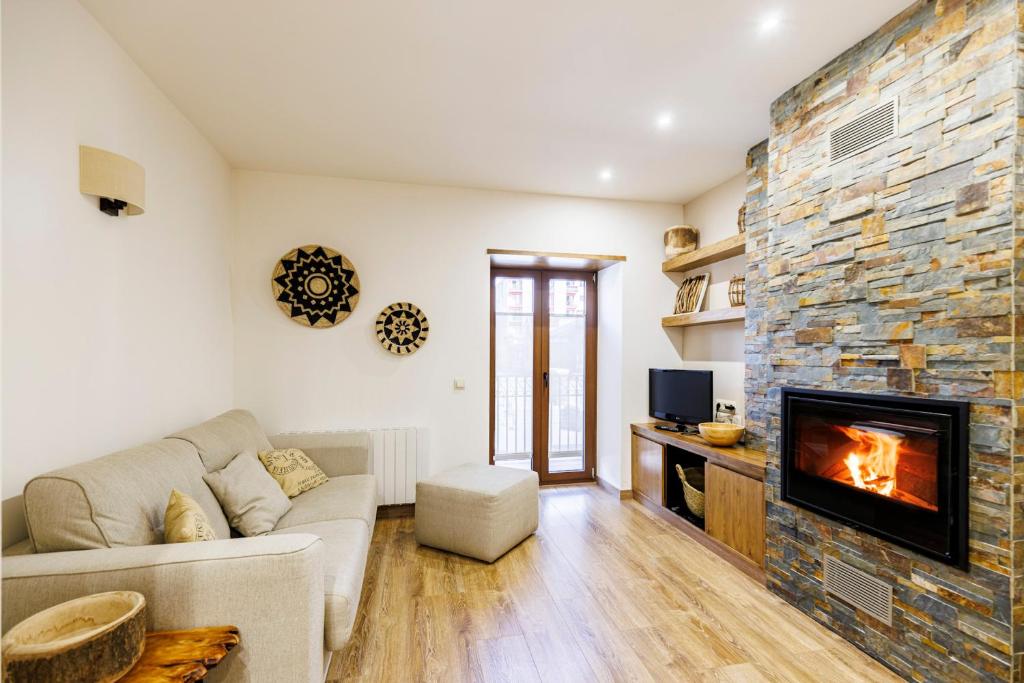 a living room with a couch and a fireplace at Hauzify I El Racó de Puigcerdà in Puigcerdà