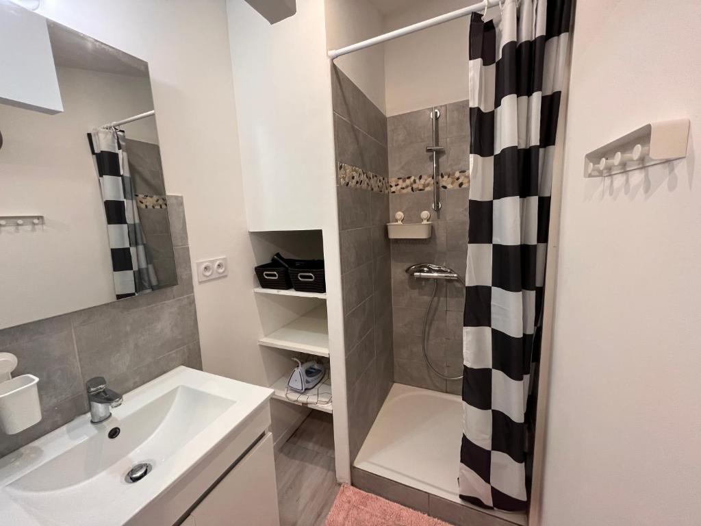 La salle de bains blanche est pourvue d&#39;une douche et d&#39;un lavabo. dans l&#39;établissement Grand studio contemporain avec mezzanine, à Sérignan