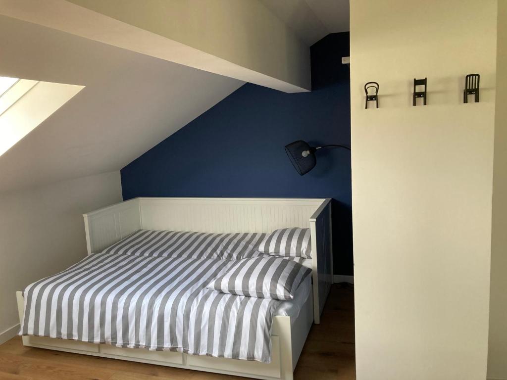 ein Schlafzimmer mit einem weißen Bett und einer blauen Wand in der Unterkunft Art & Bretzel in Ribeauvillé