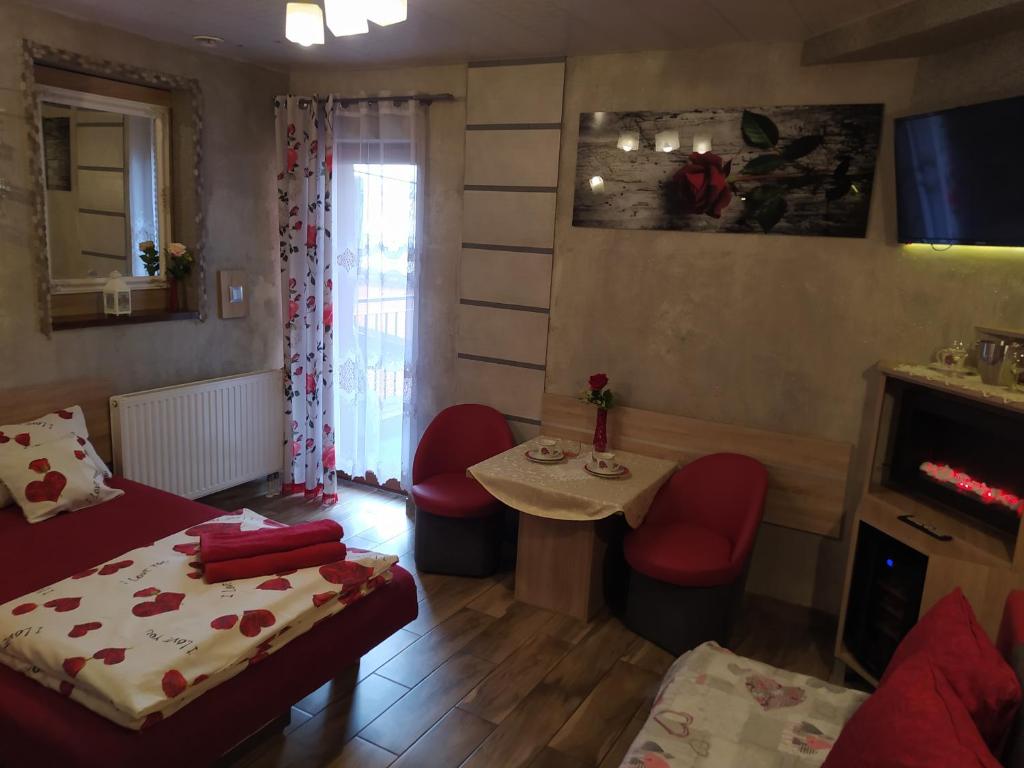 Habitación pequeña con cama, mesa y sillas en Klinkierowa Komnata, en Gniezno
