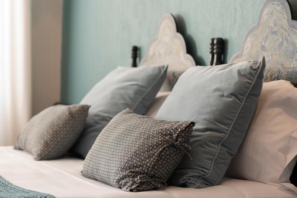 um monte de almofadas sentadas numa cama em Hotel Spa Azteca Barcelonnette em Barcelonnette