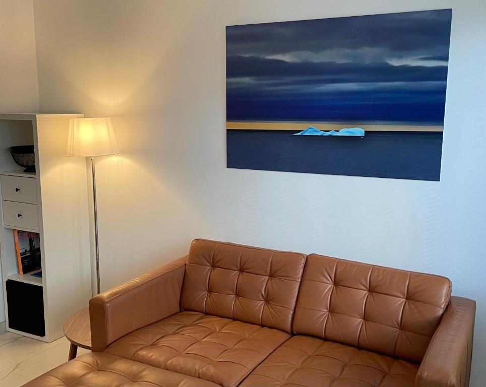 a brown couch in a living room with a painting at O9 KOK appt 3 chambres à 50 m de la mer in Koksijde