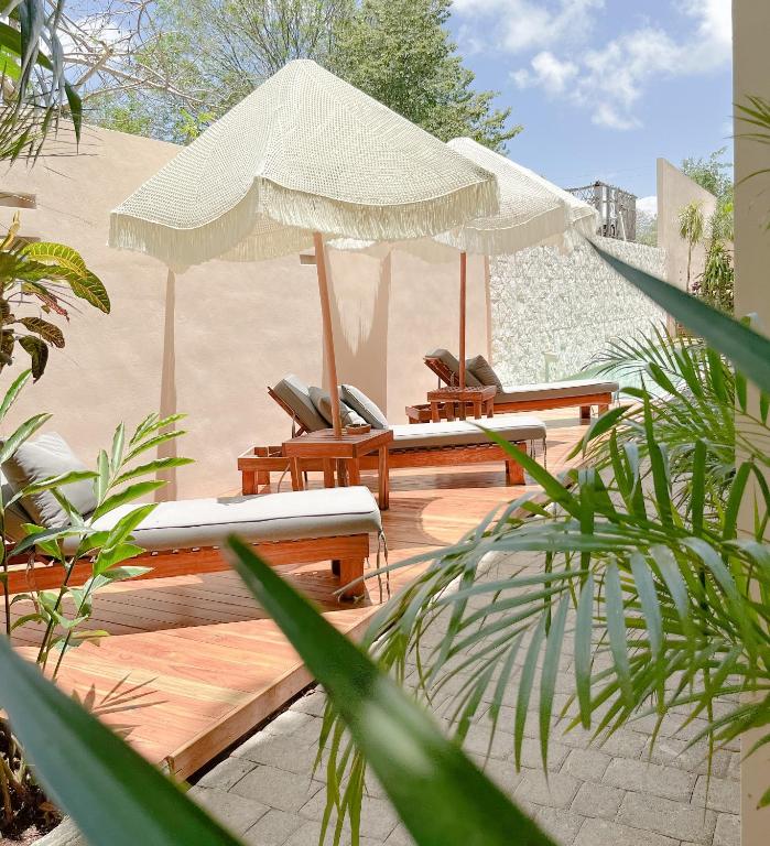 a wooden deck with chairs and umbrellas at La Veleta luxury condos in Tulum