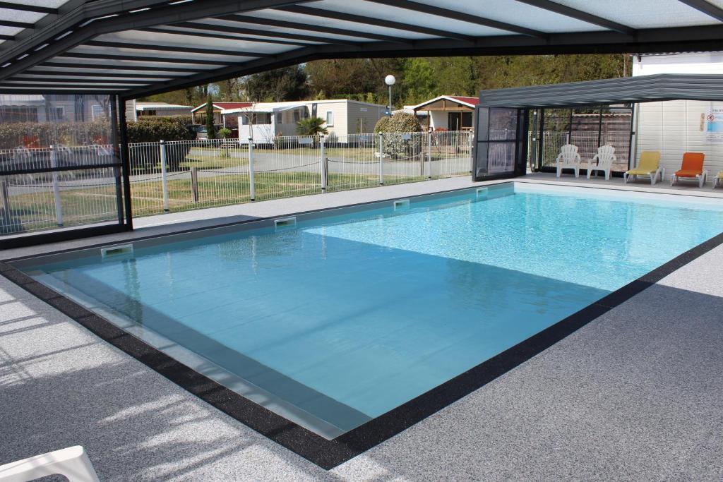 a large swimming pool with a canopy at Camping La Chênaie in Les Mathes