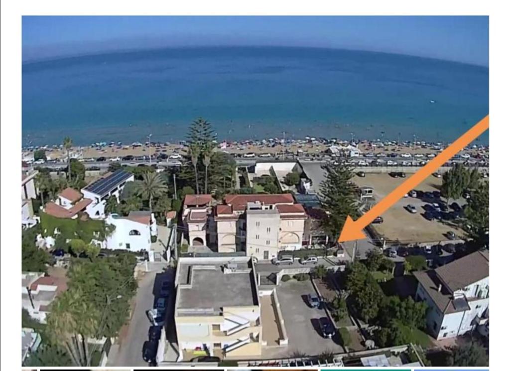 Una flecha naranja apunta a una casa frente al océano. en Aria di Mare en Noto Marina