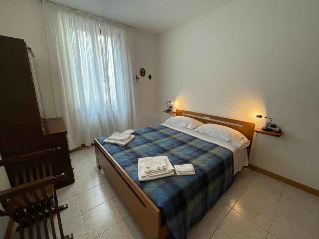 1 dormitorio con 1 cama con 2 toallas en Cozy apartment with private parking on Domaso's lakeside - Larihome A09, en Domaso