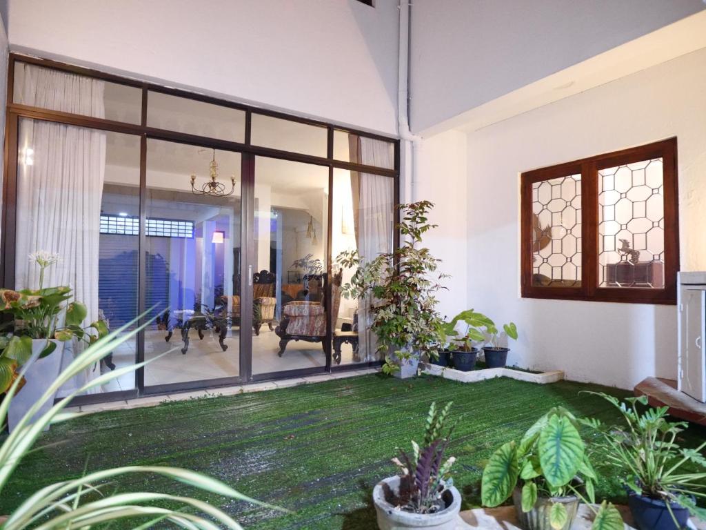 a living room with glass doors and plants at Elegance Oasis, Colombo 3 in Colombo