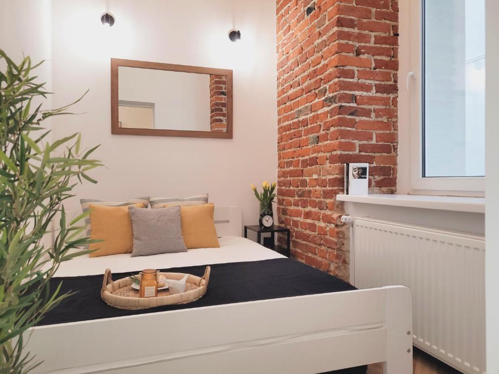 a bedroom with a bed and a brick wall at Narutowicza 41 Apartments in Łódź