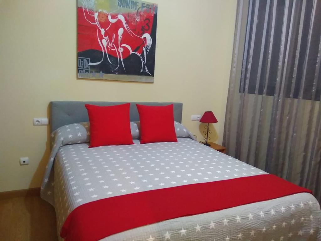 a bedroom with a large bed with red pillows at Apartamento Moncofar playa in Moncófar