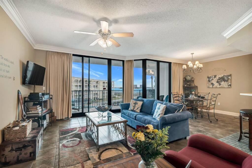 ein Wohnzimmer mit einem blauen Sofa und einem Tisch in der Unterkunft Phoenix on the Bay II 2308 - Captivating Bayfront & Dog Friendly Condo! in Orange Beach