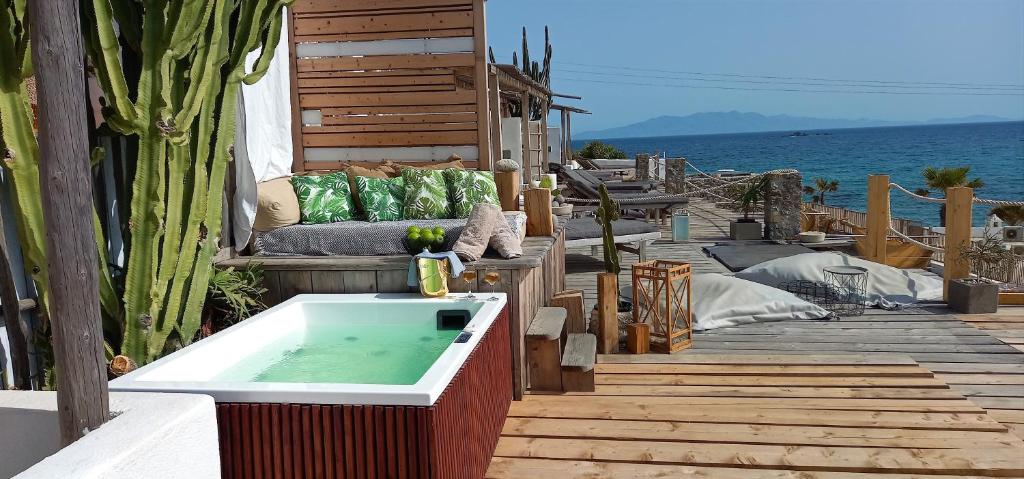 a bath tub sitting on a deck next to the ocean at Sea Side Studios & Houses in Kalo Livadi