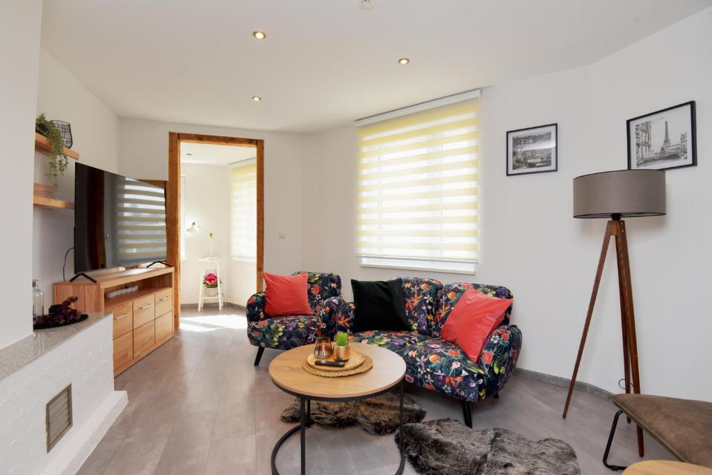 a living room with a couch and a table at Ferienwohnung in ruhiger Lage von Zella-Mehlis/ Wohnung Carola in Zella-Mehlis