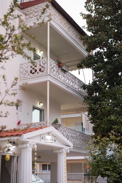 a white house with a balcony on the side of it at Ronzi Apartments in Kamena Vourla