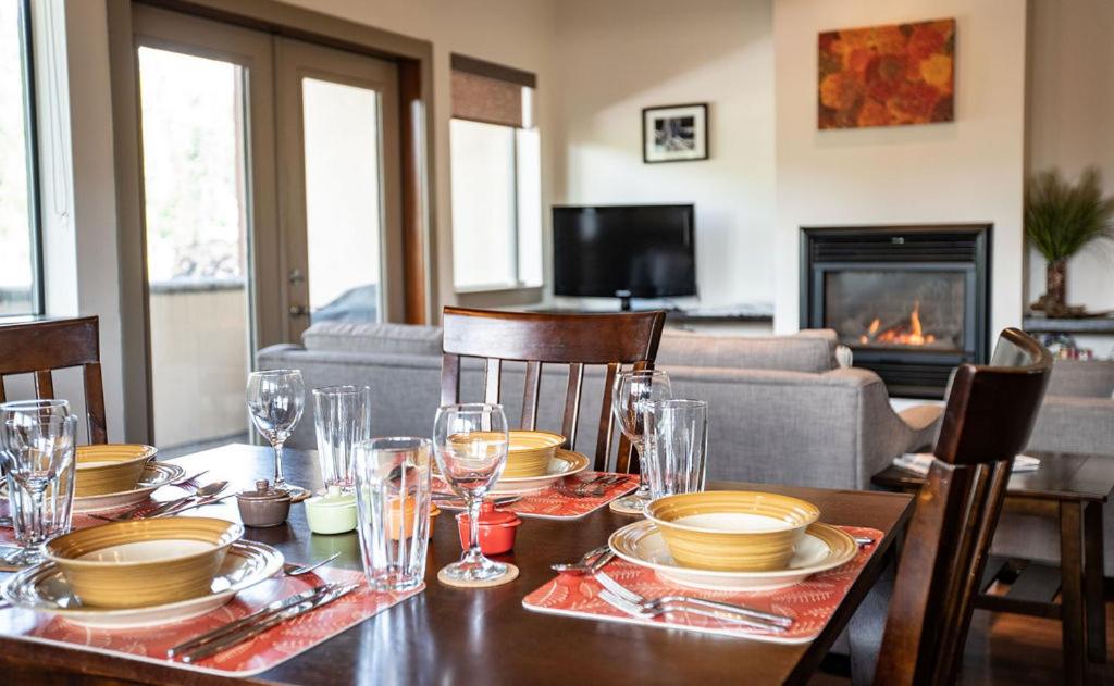 a dining room table with plates and glasses on it at Lux Downtown Condo by Revelstoke Vacations in Revelstoke