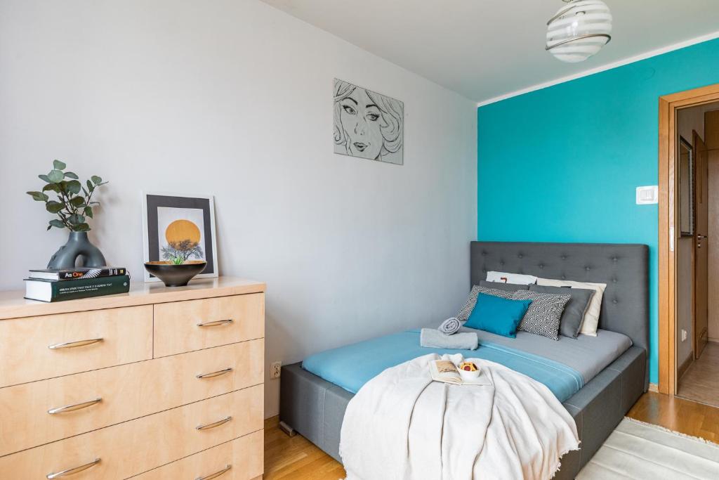 a bedroom with a bed with a blue wall at SuperApart Dolna 4 in Warsaw