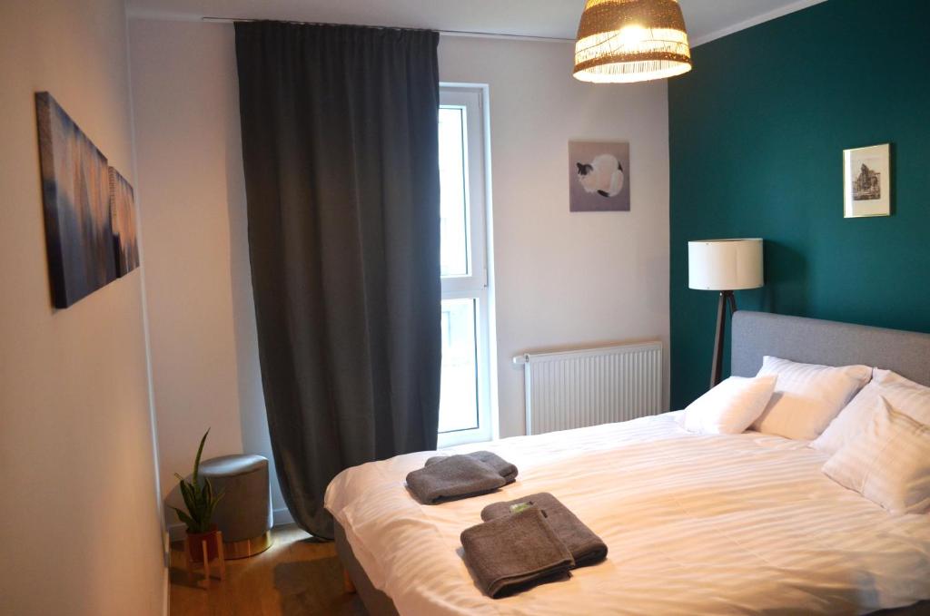 1 dormitorio con 1 cama con 2 toallas en Lighter Apartment, en Gdansk