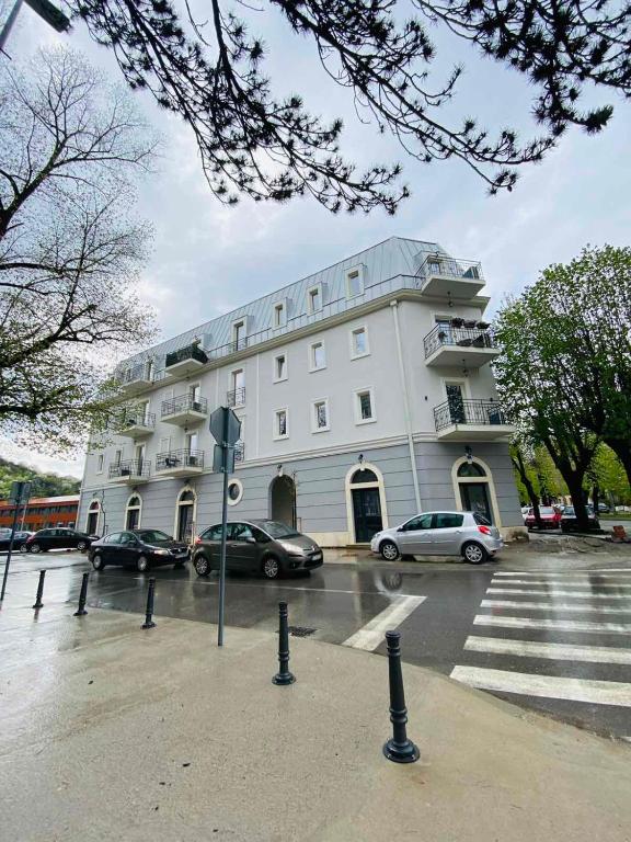 a large white building with cars parked in a parking lot at Apartment DORA in Cetinje