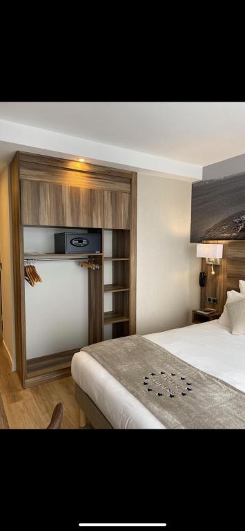 a hotel room with a bed and a tv at Hotel Europa in Quiberon