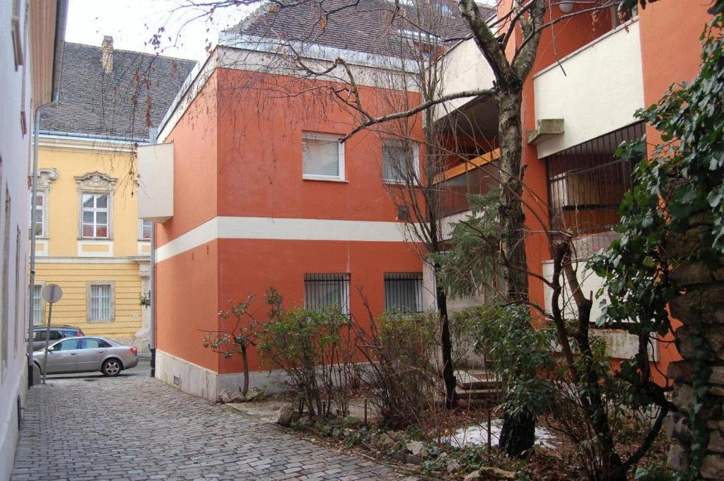 ein rot-weißes Gebäude an der Straßenseite in der Unterkunft Buda Castle Apartments in Budapest
