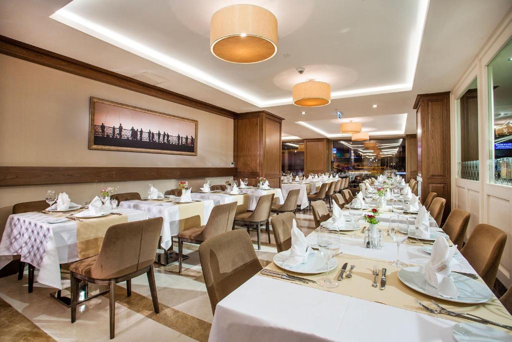 a dining room with white tables and chairs at Nidya Hotel Galataport in Istanbul