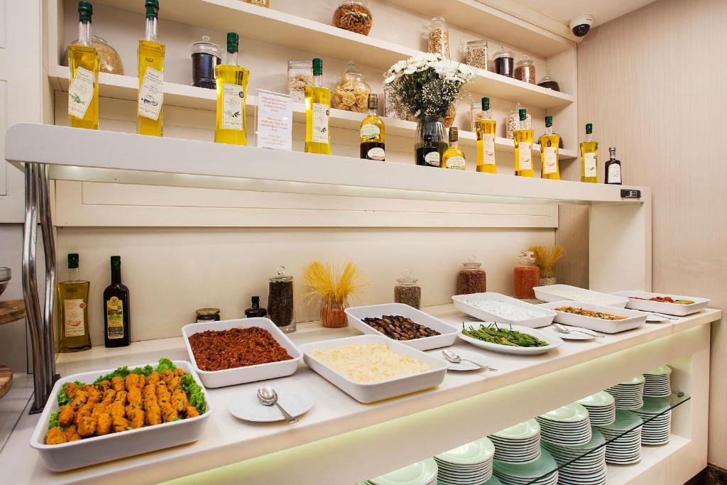 a buffet with dishes of food on a shelf at Nidya Hotel Galataport in Istanbul