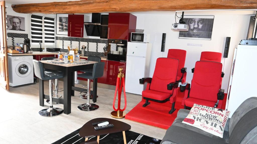 een woonkamer met rode stoelen en een tafel bij CINEMA Appartement 10mn Aeroport Roissy CDG in Villeneuve-sous-Dammartin