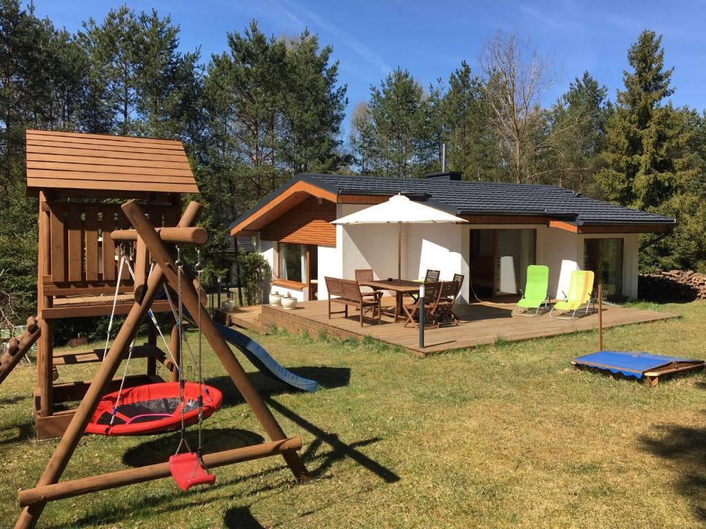 un cenador y un parque infantil con una casa en MAJKÓWKA, en Łąkie