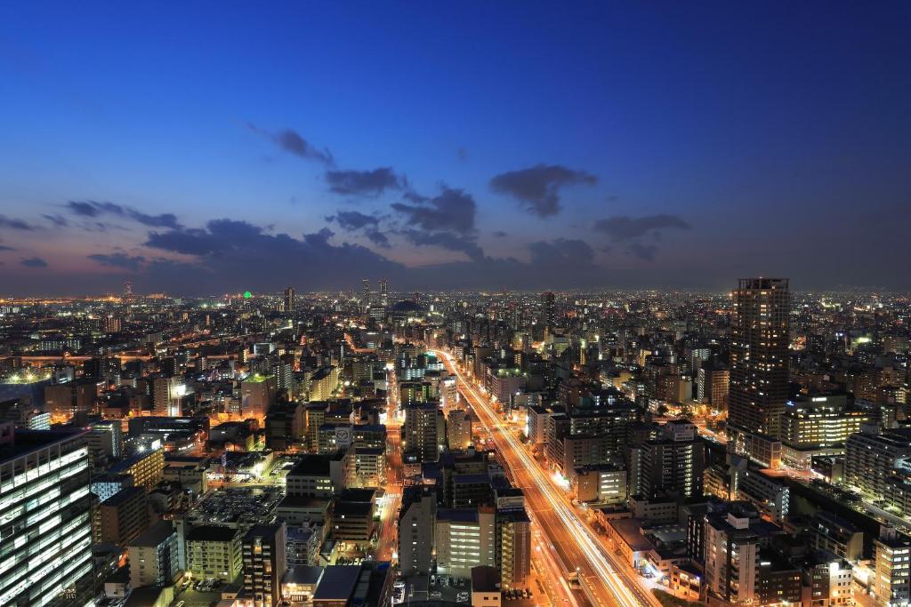 a city lit up at night with traffic at Hotel Monterey Grasmere Osaka in Osaka