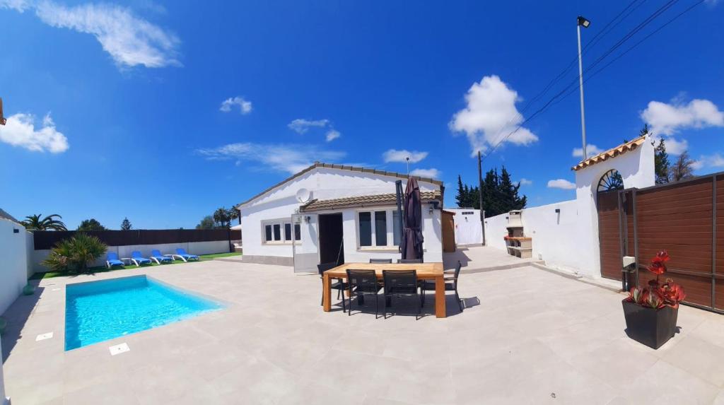 a backyard with a pool and a house at VILLA SANCTI PETRI in Chiclana de la Frontera