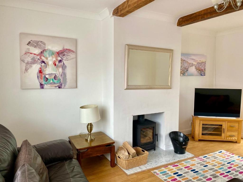 a living room with a cow painting on the wall at Sunnyhill in Witley