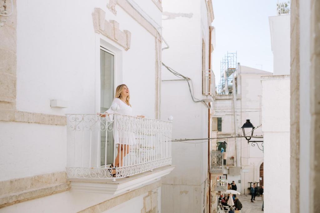 a woman standing on the balcony of a building at Dimora Anderì in Polignano a Mare