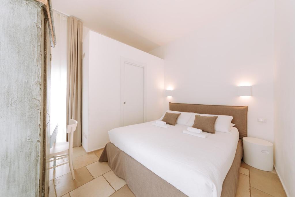 a bedroom with a large white bed and a window at Dimora Anderì in Polignano a Mare