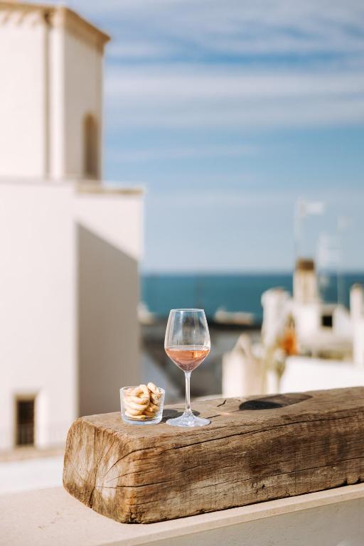 a glass of wine sitting on top of a table at Dimora Anderì in Polignano a Mare