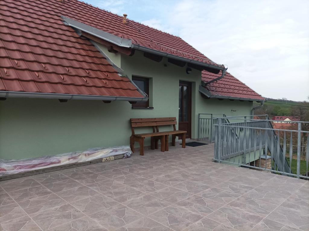 un patio con un banco y una casa en Rodinné vinařství Guldanovi en Diváky