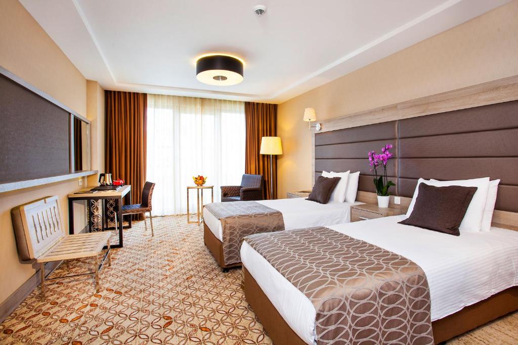 a hotel room with two beds and a television at Nidya Hotel Galataport in Istanbul