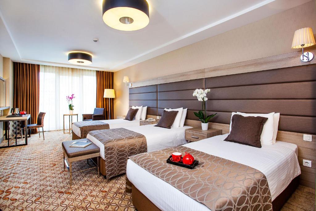 a hotel room with two beds and a desk at Nidya Hotel Galataport in Istanbul