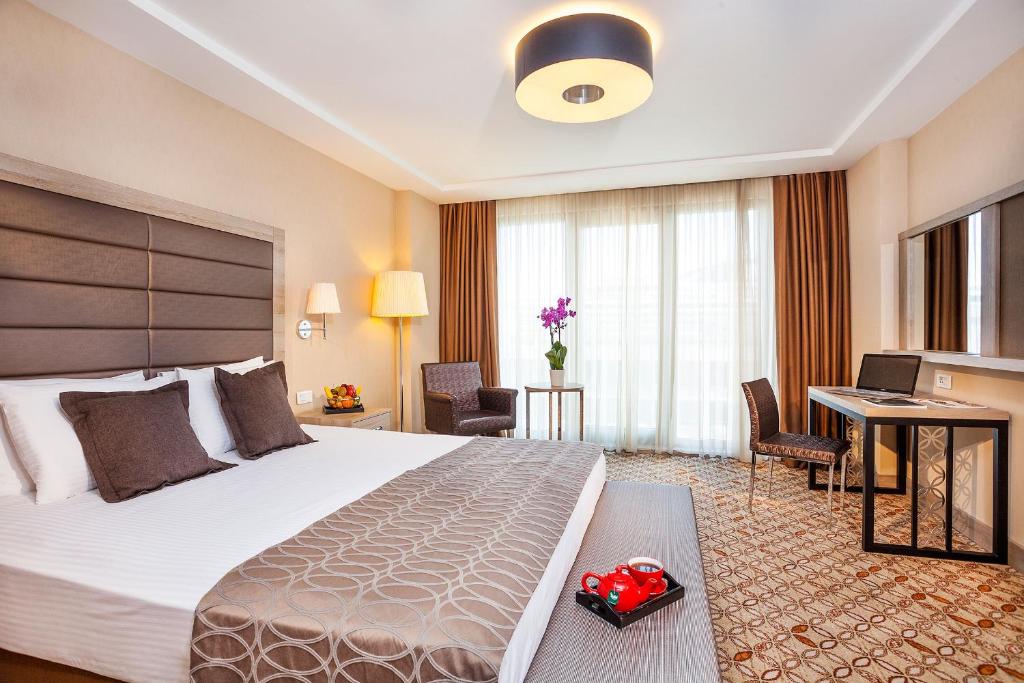 a hotel room with a large bed and a desk at Nidya Hotel Galataport in Istanbul