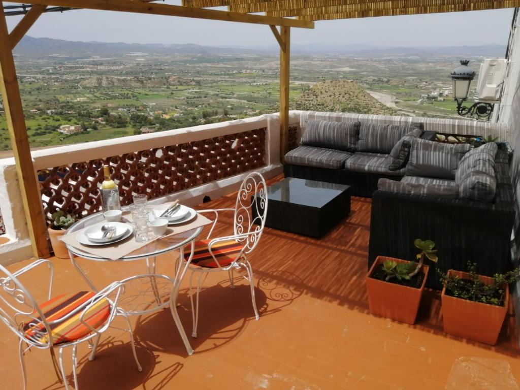 balcón con mesa, sillas y sofá en MIRAMELINDO Encantador apartamento con terraza panorámica, en Mojácar