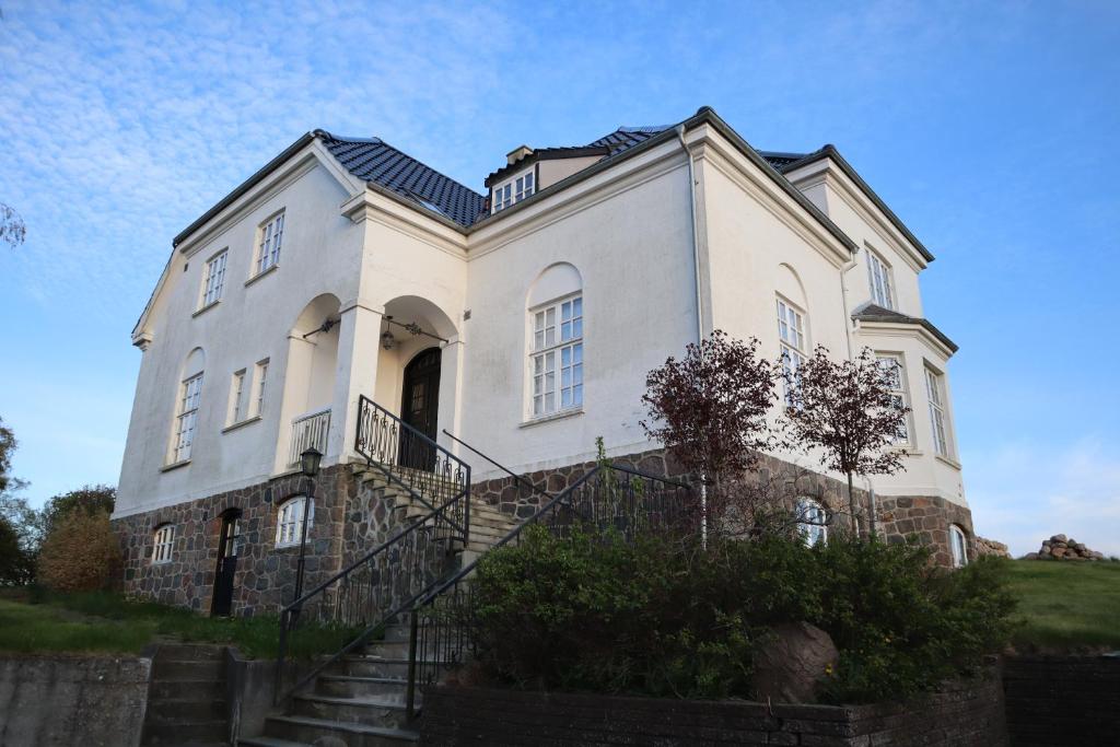 a large white house with stairs in front of it at Villa Albeck in Rønde