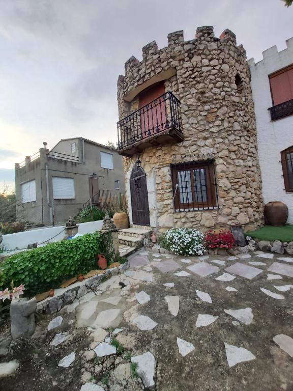 un edificio de piedra con balcón y patio en EL CASTELLET, en Traiguera
