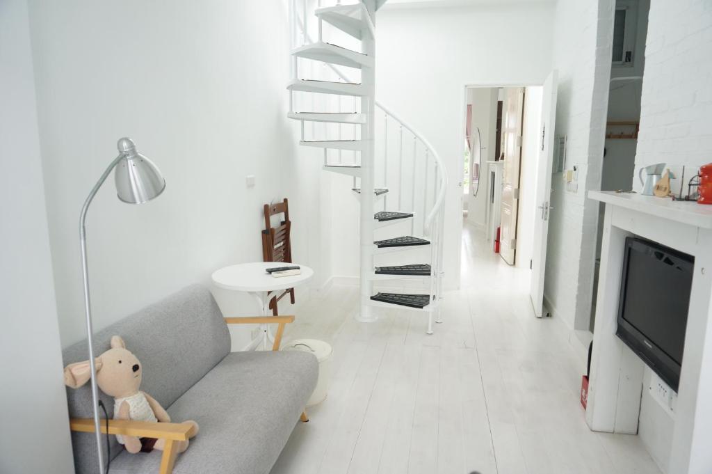 a living room with a gray couch and a staircase at Milk White Homestay in Hengchun South Gate