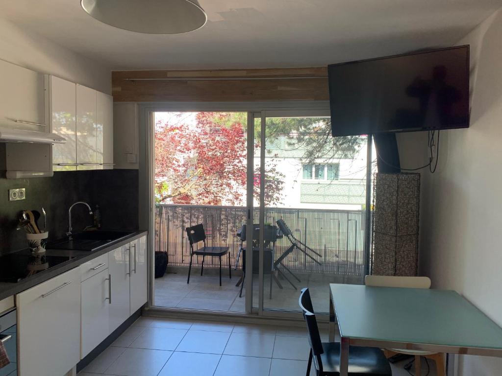 a kitchen with a sliding glass door leading to a patio at Appartement en résidence climatisé avec parking in Montpellier